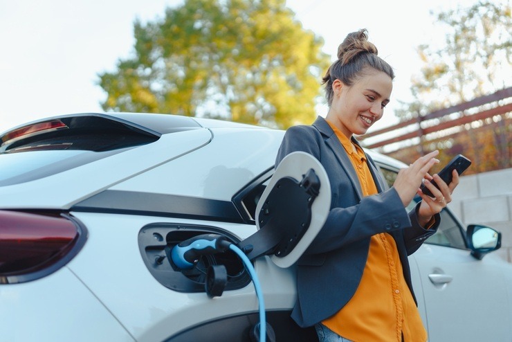 Una donna ricarica un'auto elettrica