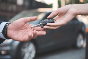 due mani si passano una chiave per auto
